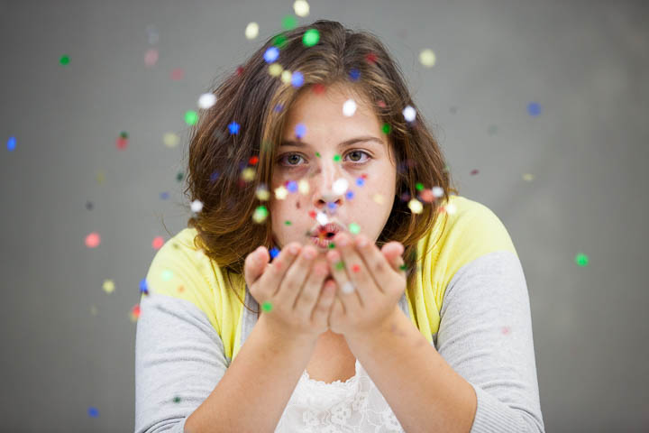 Senior girl blows confetti at the camera - Photos By Orion